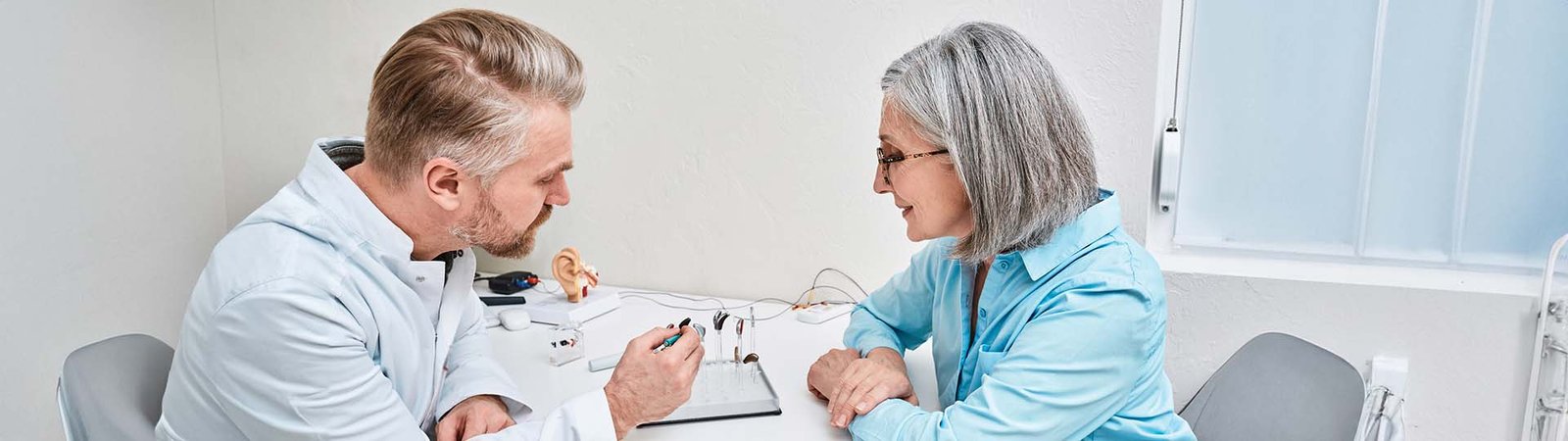 Pessoa idosa usando aparelho auditivo com dificuldade de audição